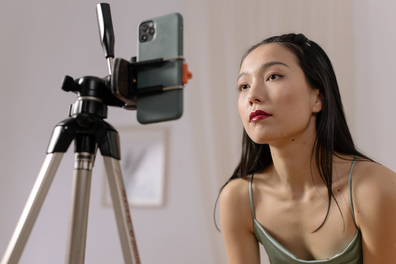 Creator framed beside a smartphone on tripod before filming